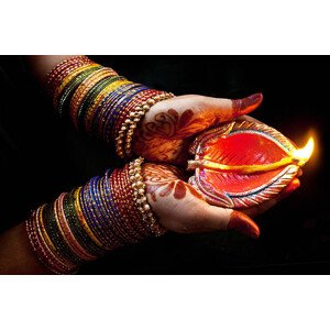 Fotografie Woman with lit earthen lamp at Diwali festival, Subir Basak, 40 × 26.7 cm
